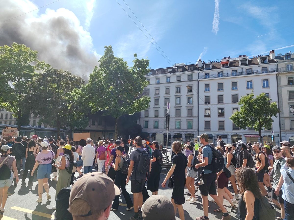 Zwarte rook boven de stoet demonstranten bij de Gare Routière
